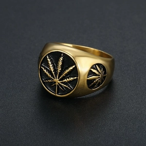 Vue macro d'une bague hip-hop pour homme avec feuille de cannabis en relief doré et noir