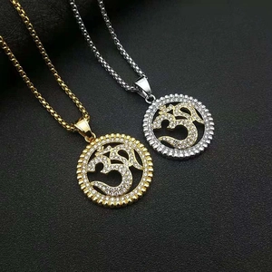 Vue macro de pendentifs Om dorés et argentés avec incrustations de zircons brillants