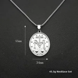 Detailansicht silberner ovaler Anhänger mit Kreuz und M-Gravur, Größe 55mm x 34mm