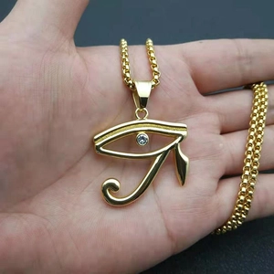 Golden Eye of Horus Egyptian amulet necklace with cubic zirconia and box chain in hand