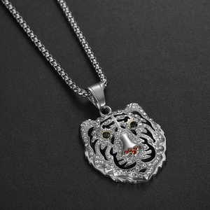 Détail du pendentif tête de tigre serti de cristaux blancs et yeux verts avec chaîne