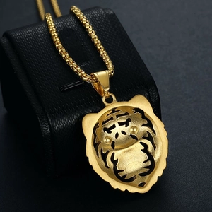 Détail du pendentif tête de tigre doré avec caractère chinois et chaîne à mailles