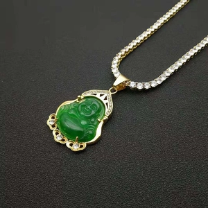 Dettaglio del ciondolo Buddha dorato con giada in resina verde e pietre di zirconia