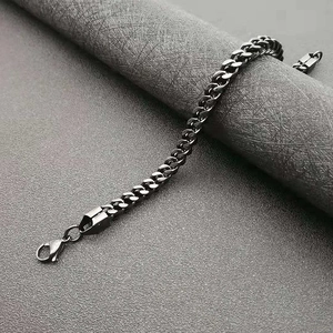 Polished matte black stainless steel curb chain bracelet for men on leather background