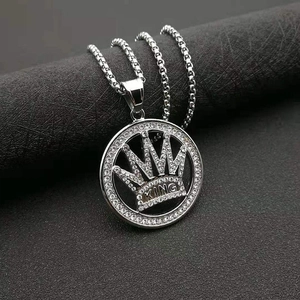Makroaufnahme von silbernem Hip-Hop-Kronenanhänger mit KING-Gravur und glitzernden Strasssteinen
