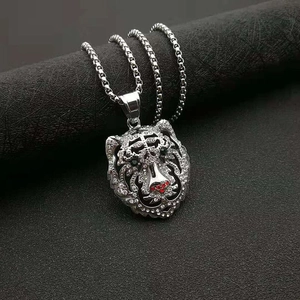 Gros plan du pendentif tigre argenté avec strass brillants et détails du nez rouge