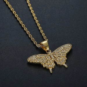 Macro shot of hip hop butterfly pendant with white rhinestones and gold twist chain