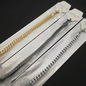 Detail view of gold, black, and silver stainless steel dragon bone chains with hang tags