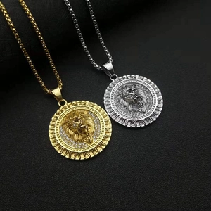 Dettaglio dei ciondoli testa di leone in oro e argento con cristalli e motivi a fiamma