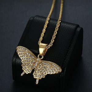 Macro shot of hip hop butterfly pendant with rhinestones on golden rope chain