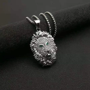 Gros plan du pendentif tête de lion hip hop avec yeux verts sur chaîne vénitienne