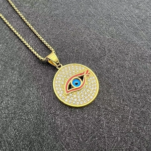 Détail du collier mauvais œil en acier inoxydable plaqué or avec cristaux sur fond