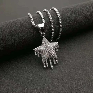 Gros plan du pendentif étoile hip-hop argenté avec strass et design de gouttelettes