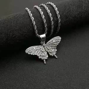 Macro shot of hip hop butterfly pendant featuring sparkling white zircons on rope chain