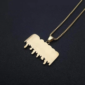 Gros plan du pendentif doré effet goutte avec texture brossée sur une chaîne box