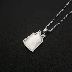 Macro detail of jersey-shaped pendant and rope chain necklace with frosted metal finish