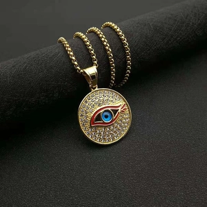 Détail du collier pendentif œil maléfique doré avec zircons pavés sur fond noir