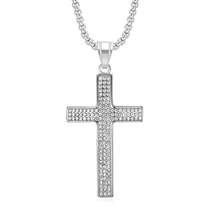 Détail d'un pendentif croix serti de zircons pavés sur une épaisse chaîne maille miroir