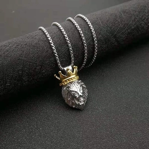Iced out crown lion head pendant necklace in silver and gold tone on a display stand
