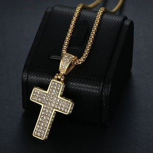 Iced out gold plated hip hop cross necklace with sparkling cubic zirconia on black stand