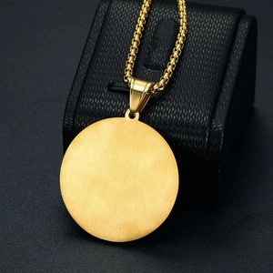 Detalle del colgante cabeza de león bañado en oro con cadena box sobre estuche negro