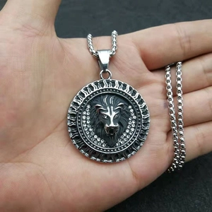Pendentif tête de lion en acier inoxydable poli avec strass blancs présenté sur la main