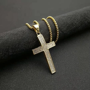 Vue macro d'un pendentif croix en or hip hop avec pavé de diamants sur chaîne box