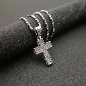 Close-up of hip-hop cross pendant with micro-paved zircons on silver box chain