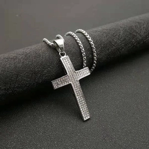 Détail du pendentif croix argenté avec cristaux sertis et chaîne à mailles carrées