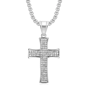 Détail du pendentif en forme de croix argentée orné de strass brillants sur chaîne solide