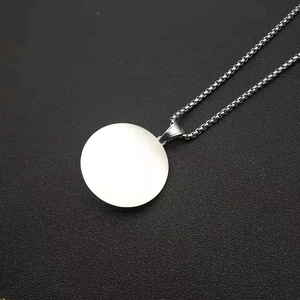 Detail view of round blank stainless steel pendant on a box chain with silver finish