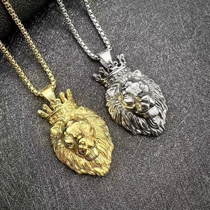 Détail des pendentifs tête de lion avec couronne en or et argent sur une chaîne box