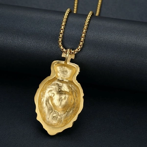 Gros plan d'un pendentif tête de lion doré montrant sa texture mate et son design creux