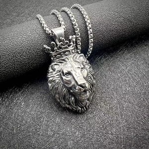 Vue détaillée du pendentif tête de lion à couronne en argent sur une grosse chaîne box