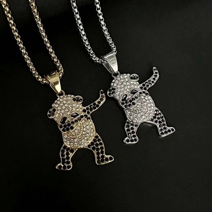 Vue détaillée des pendentifs panda dabbing dorés et argentés avec strass brillants