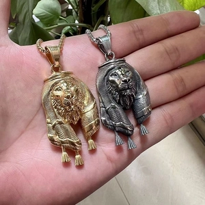 Gros plan sur des pendentifs tête de lion en or et argent avec détails de foulard