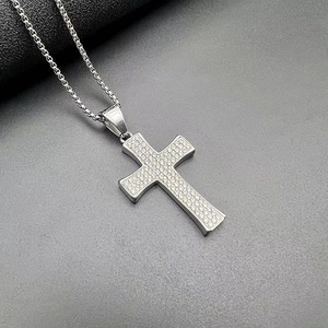 Détail du pendentif croix hip-hop argenté serti de strass brillants et d'une chaîne box