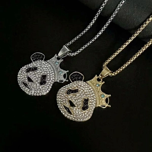 Détail de pendentifs panda en or et argent avec couronnes et strass bleus étincelants