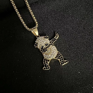 Gros plan du pendentif panda hip hop avec strass noirs et blancs sur chaîne dorée