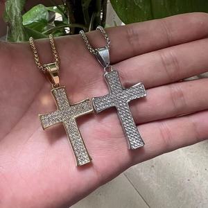 Gros plan de pendentifs croix hip hop or et argent sertis de zircons cubiques sur des chaînes