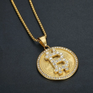 Collier avec pendentif Bitcoin plaqué or et zircons blancs sur fond gris foncé
