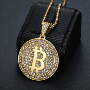 Dettaglio macro del ciondolo Bitcoin placcato oro con strass su espositore nero