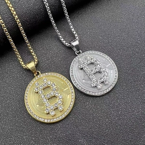 Vue macro des pendentifs Bitcoin or et argent avec strass sur fond de cuir noir texturé