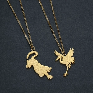 Gold stainless steel tiger and crane pendant necklaces with O-link chains on grey background