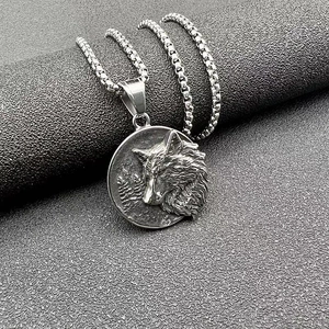 Macro shot of 3D viking wolf head relief on a round silver steel pendant with box chain