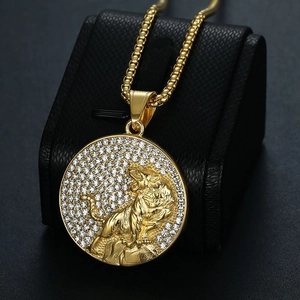 Gold-plated tiger pendant necklace with sparkling rhinestones on a black leather stand