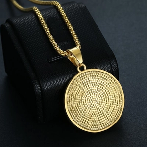 Detail of gold world map pendant with spiral texture on black leather jewelry box