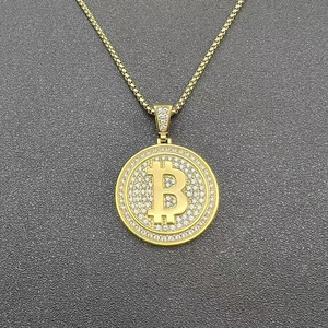 Vista macro del ciondolo Bitcoin dorato con cristalli scintillanti e catena a scatola