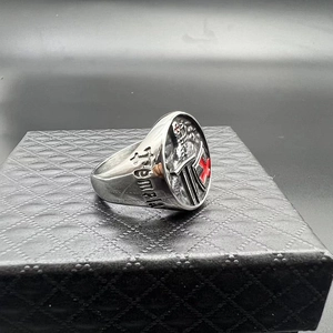 Macro detail of red enamel cross and Templar engraving on polished steel ring