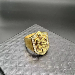 Dettaglio dell'anello a sigillo dorato con rilievo cavaliere e cornice di strass lucidi